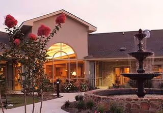 Exterior view of Eagle Crest Rapid Recovery with a fountain and illuminated entrance.