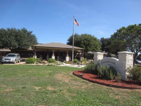 Front view of Silver Pines Nursing and Rehabilitation Center with flagpole and landscaped entrance.