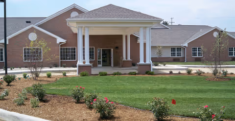 Front view of The Oaks at North Pointe Woods senior living facility with landscaped lawn.