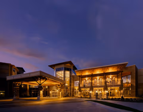Exterior night view of Edgewater, a WesleyLife Community, with a warmly lit entrance.