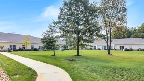 Maple Lake Assisted Living and Memory Care exterior with green lawn and curved path.