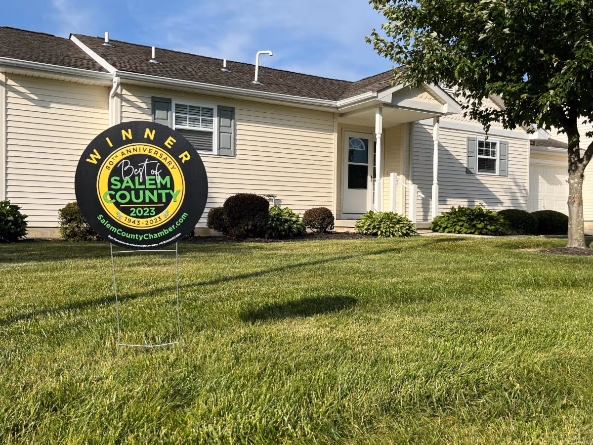 Front lawn and entrance of a single-story building with a circular 'Winner Best of Salem County 2023' yard sign.