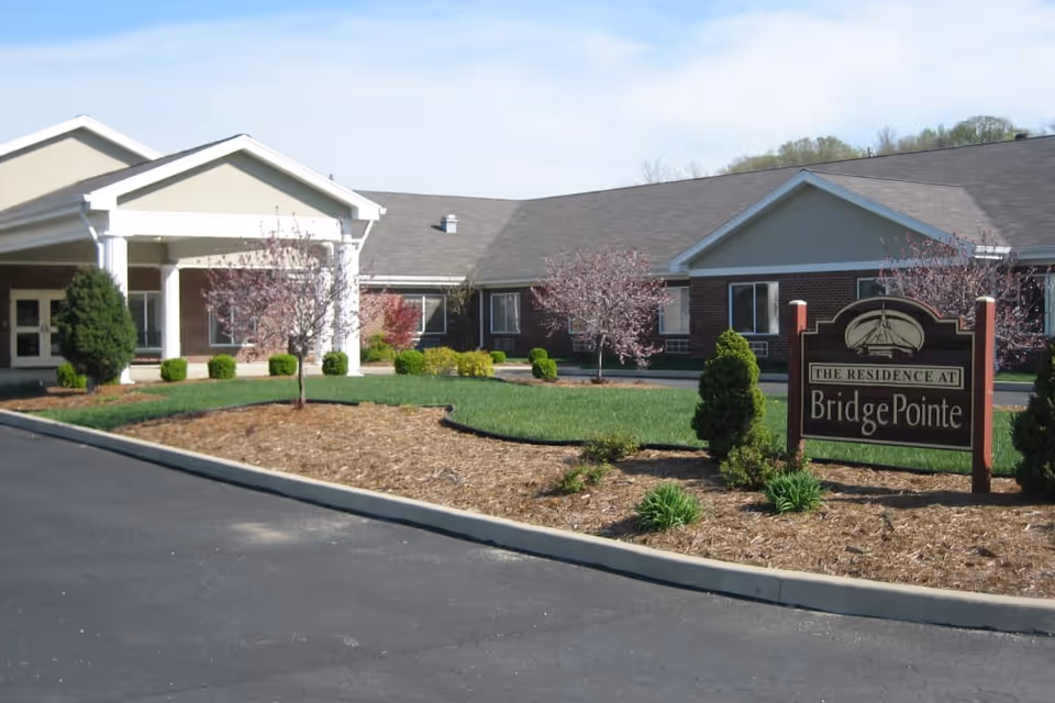 Front entrance and landscaped grounds of BridgePointe Health Campus with a driveway and a sign reading 'BridgePointe'.