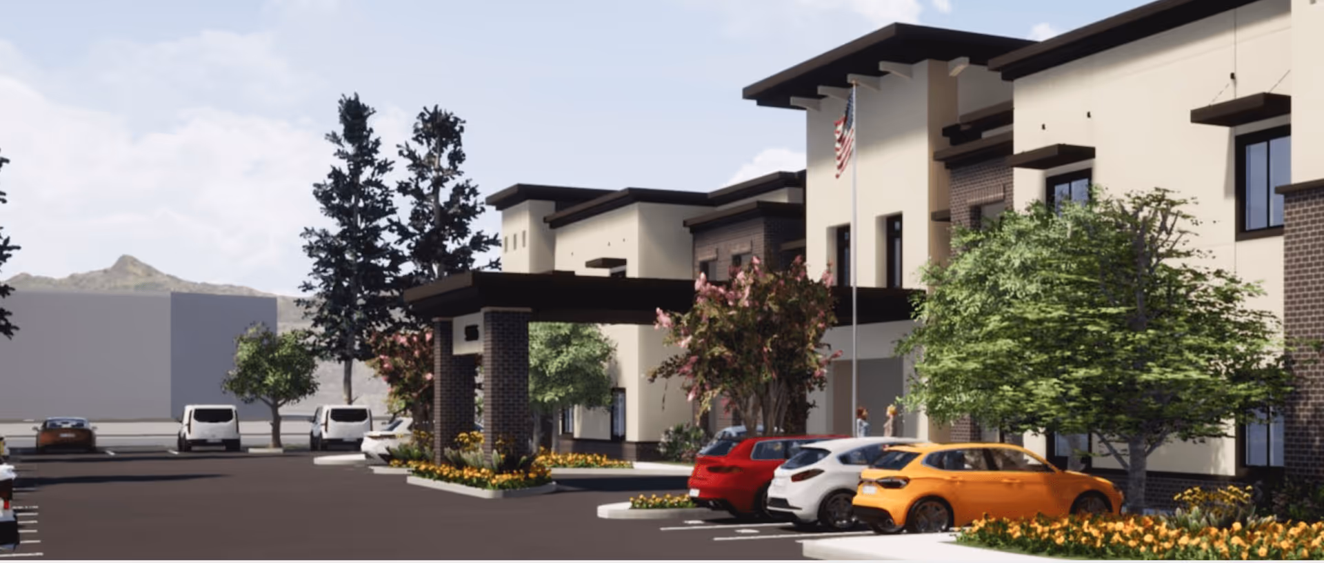 Exterior view of Aqua Ridge of Montclair senior living facility showing a modern building with a covered entrance, several parked cars, trees, and landscaping with flowers under a partly cloudy sky.