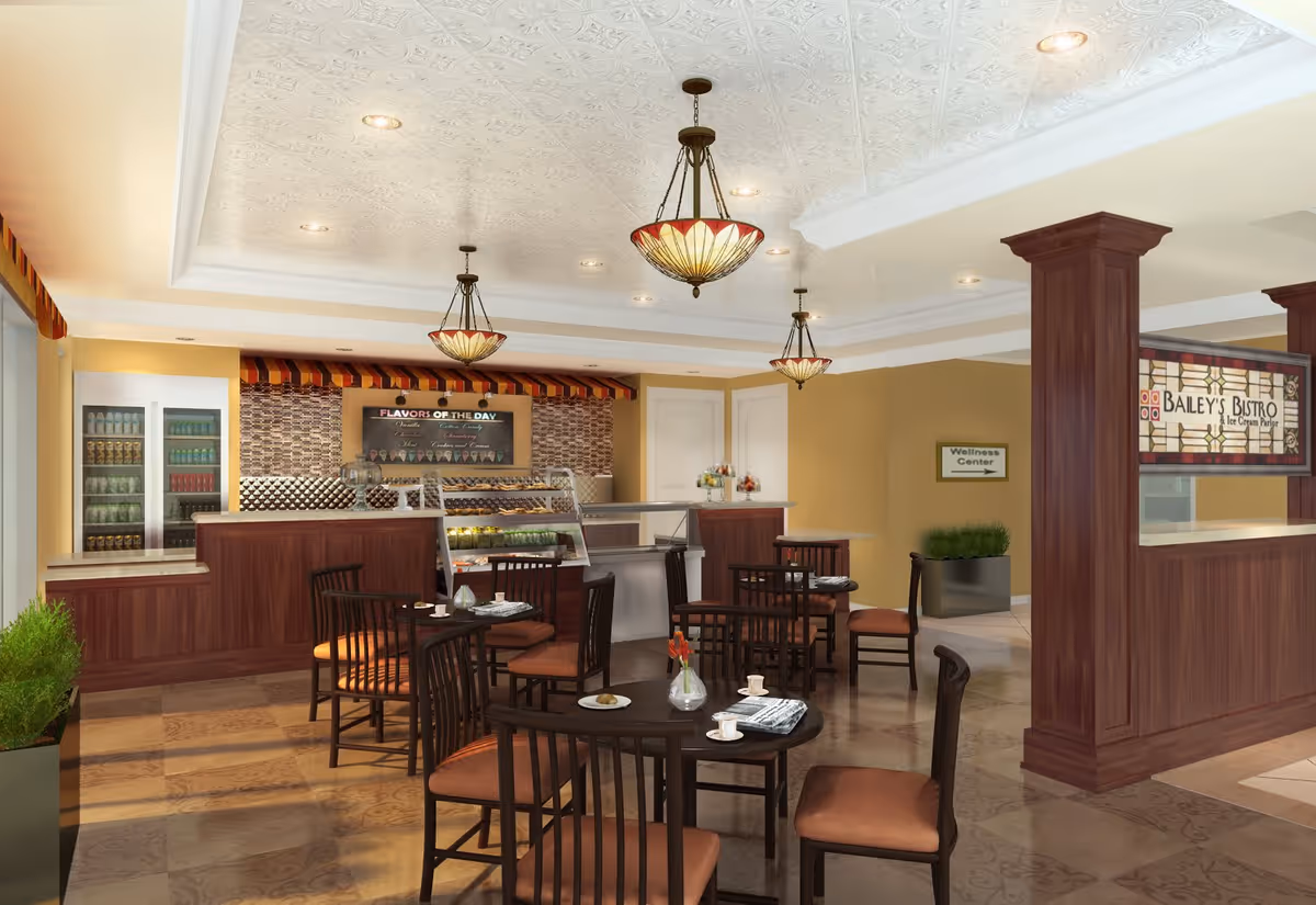 Interior view of Bailey's Bistro, an ice cream parlor and cafe area with several round tables and chairs. The counter displays various food items and a menu board labeled 'Flavors of the Day'. The space has warm lighting with decorative ceiling fixtures, wood paneling, and a sign indicating the Wellness Center in the background.