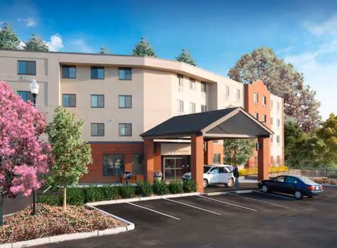 Exterior view of Highlands on the East Side, a senior living building with a covered entrance.
