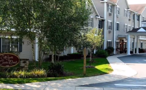 Exterior view of HarborChase of Madison senior living with landscaped entrance and curved driveway.