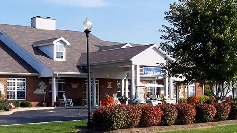 Rosegate Commons exterior entrance with covered drop-off and landscaped front yard.