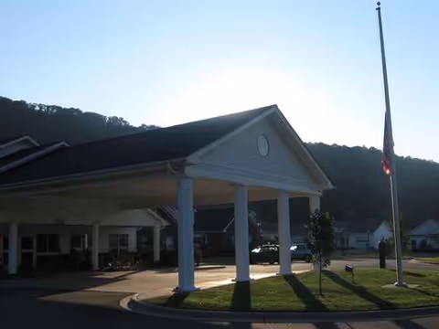Forest Ridge Assisted Living facility entrance with a porte-cochere and flagpole.