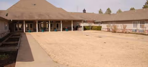 Heritage Grove facility exterior with a covered front walkway and open gravel courtyard