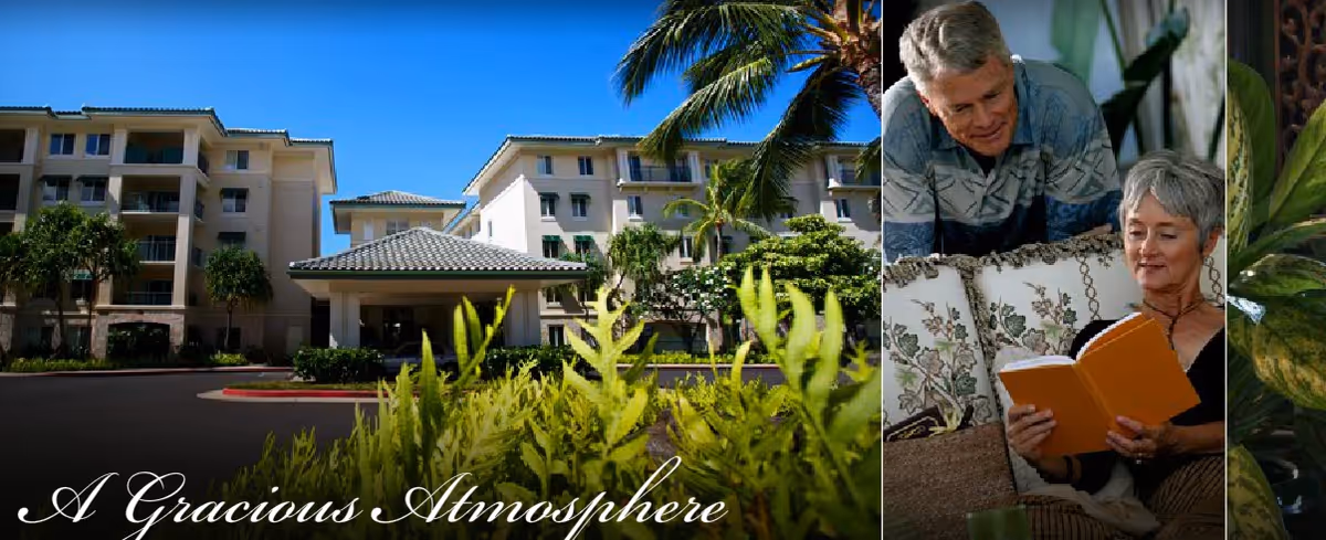 Exterior view of a multi-story senior living facility building with a covered entrance, surrounded by palm trees and greenery under a clear blue sky. To the right, an elderly woman is sitting on a floral-patterned couch reading a book, while an elderly man leans over the back of the couch looking at her. The text 'A Gracious Atmosphere' is visible at the bottom left.