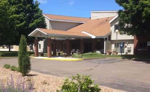 Exterior view of Dove Healthcare Barron Assisted Living with a covered entrance and driveway.