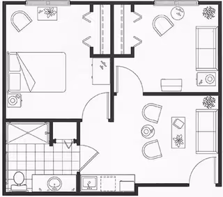 Black and white architectural floor plan of a one-bedroom assisted living suite showing a bedroom with a bed and chair, a living room with two chairs, a sofa, and a coffee table, a bathroom with a shower, toilet, and sink, and a small kitchen area with a sink and counter space.