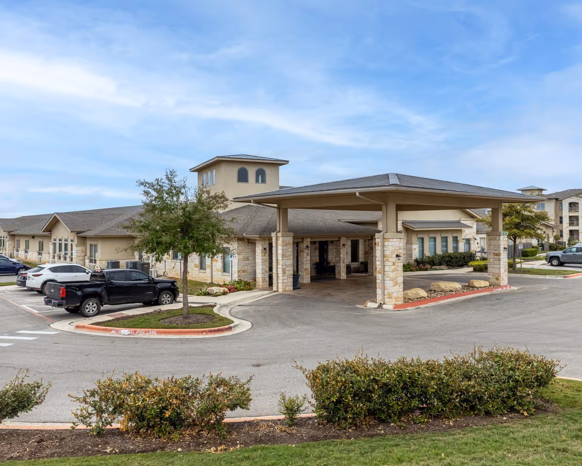Exterior view of Ledgestone Senior Living entrance with covered drop-off and parking.