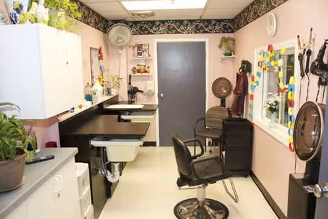 Interior of a senior living facility hair salon with mirrors, chairs, and styling equipment.