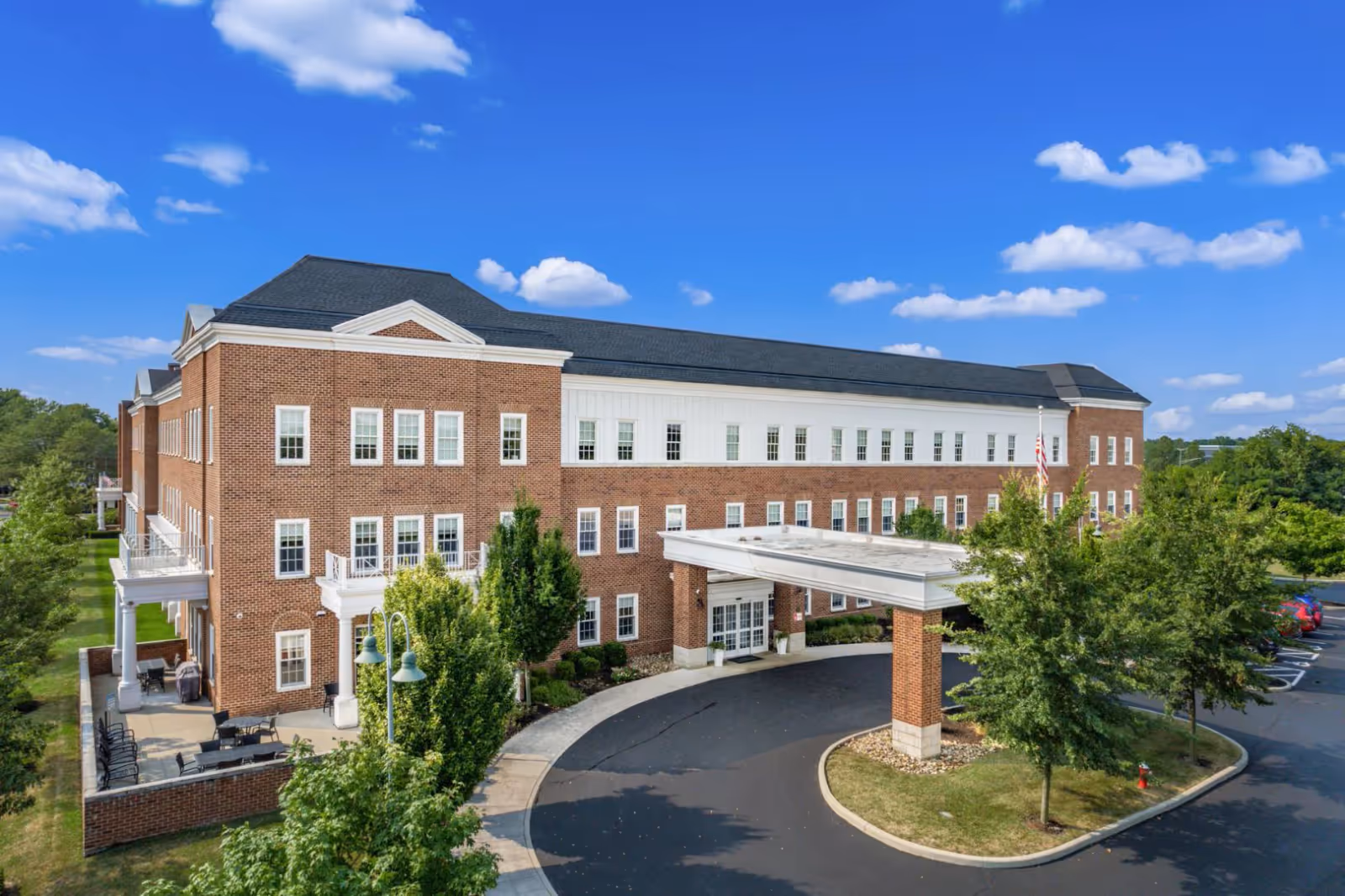 Brick, multi-story senior living facility with a curved driveway and covered entrance.
