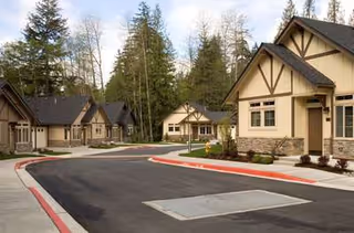 The Lodge at Mallard's Landing exterior with residential-style cottages along a curved road.