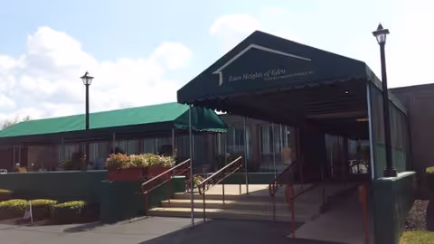 Front entrance of Eden Heights of Eden featuring a ramp, stairs, and awning.
