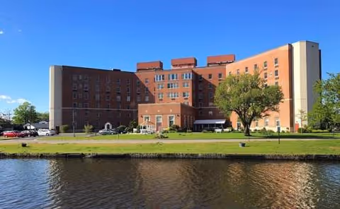 Exterior view of Seaton Ocean Grove senior living building along a river.