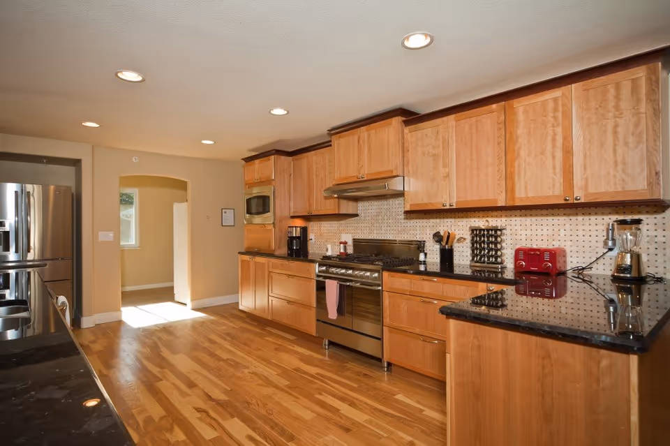 Bright kitchen in Applewood Our House Assisted Living with wooden cabinets and stainless appliances.