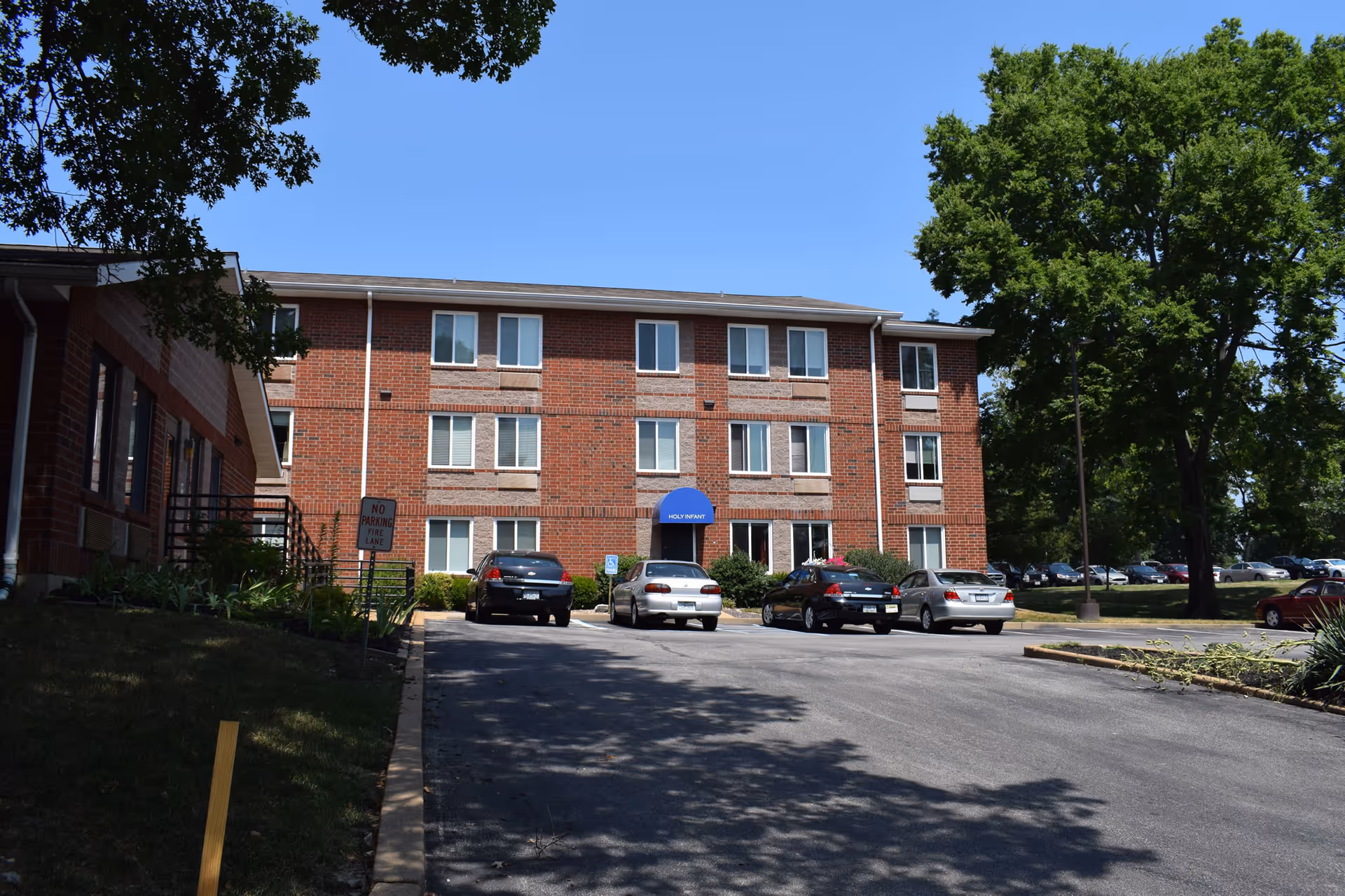 Exterior view of Cardinal Ritter Senior Services building featuring a brick facade and parking area.