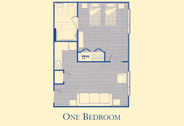 Floor plan of a one-bedroom apartment showing a bedroom with three beds, a bathroom, a kitchen area, and a living room with a sofa and chairs.