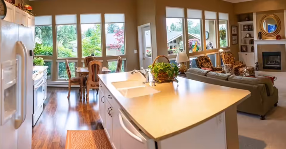 Bright open-concept kitchen with island flows into dining and living areas.