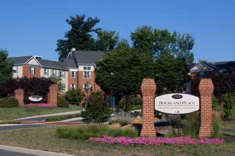 Rockland Place entrance with brick columns and manicured landscaping