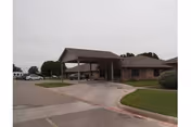 Front view of Country Home Estates senior facility with a covered entrance and driveway.