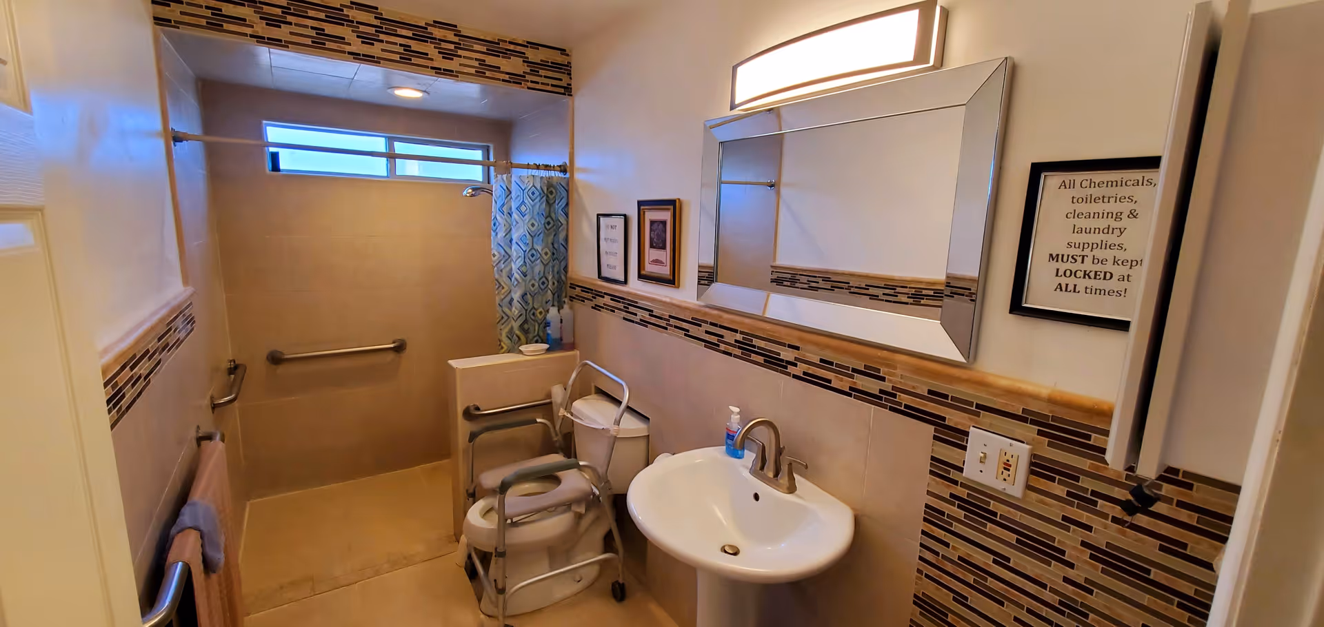 Accessible bathroom in a senior living facility with a walk-in shower, grab bars, and sink.