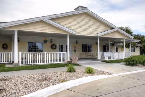 Cottonwood Senior Living's single-story front porch with seating and columns.