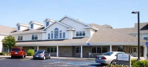 Exterior view of Brookdale Utica senior living facility with parked cars in front.
