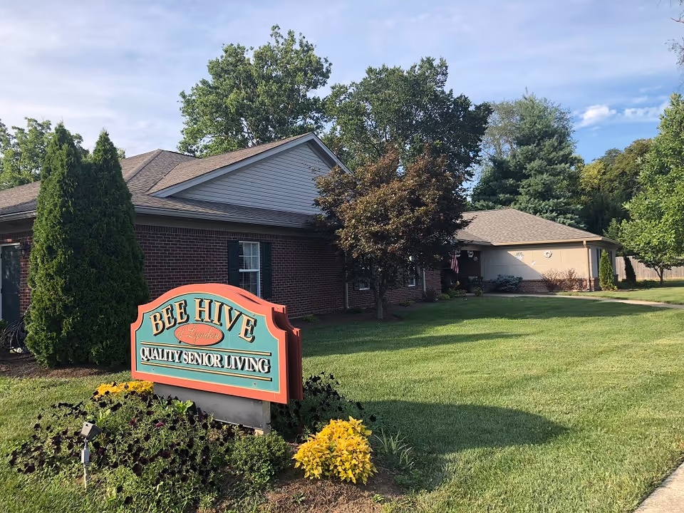 Bee Hive Lyndon exterior with sign, brick building, and manicured lawn