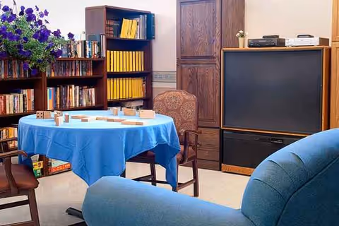 Interior living room at Riverside Nursing & Rehab Center with round table, blue tablecloth, and seating.