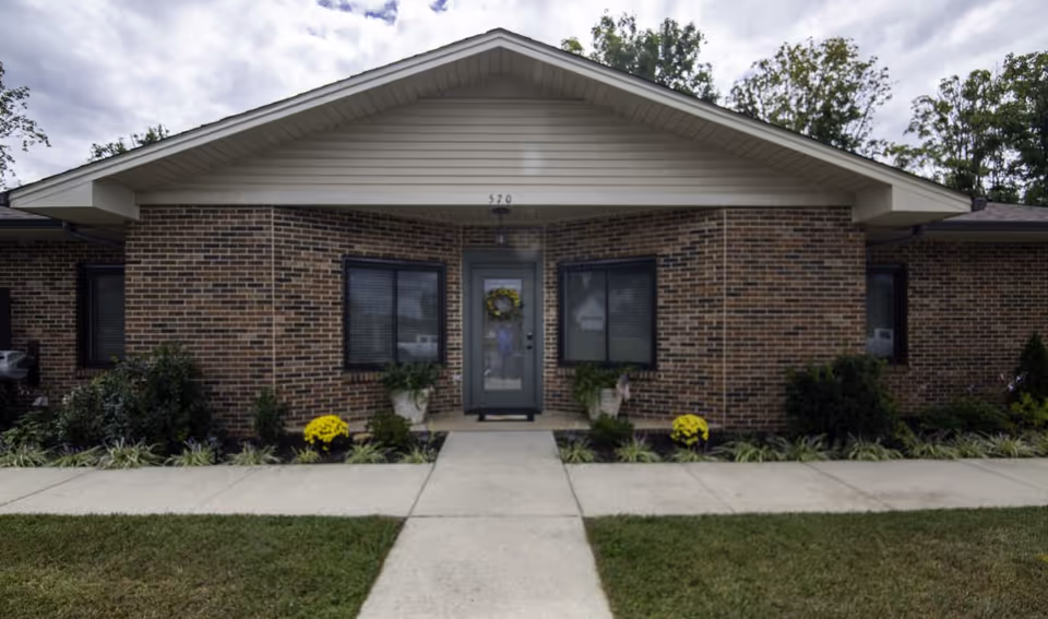 Front view of Pleasant Places by Majestic Residences entrance, brick exterior with walkway and landscaping.