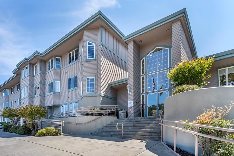 Exterior view of Brookdale San Ramon senior living building with glass entrance and stairs.