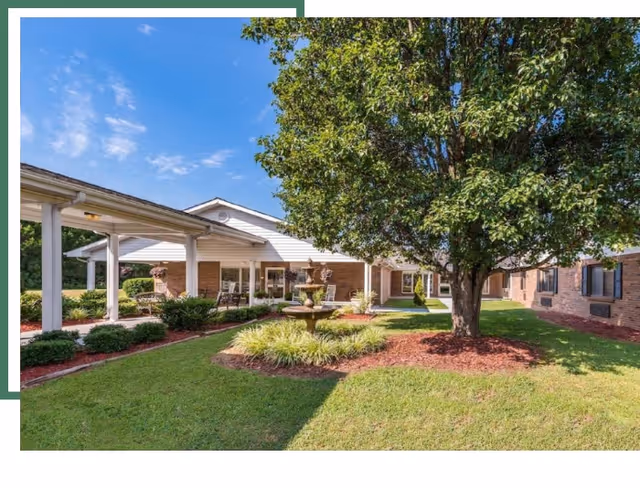 Exterior view of Clayton Rehabilitation and Healthcare Center with fountain, lawn, and trees.