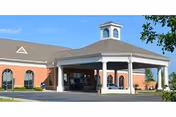 Brick exterior of a senior living facility with a covered portico entrance.