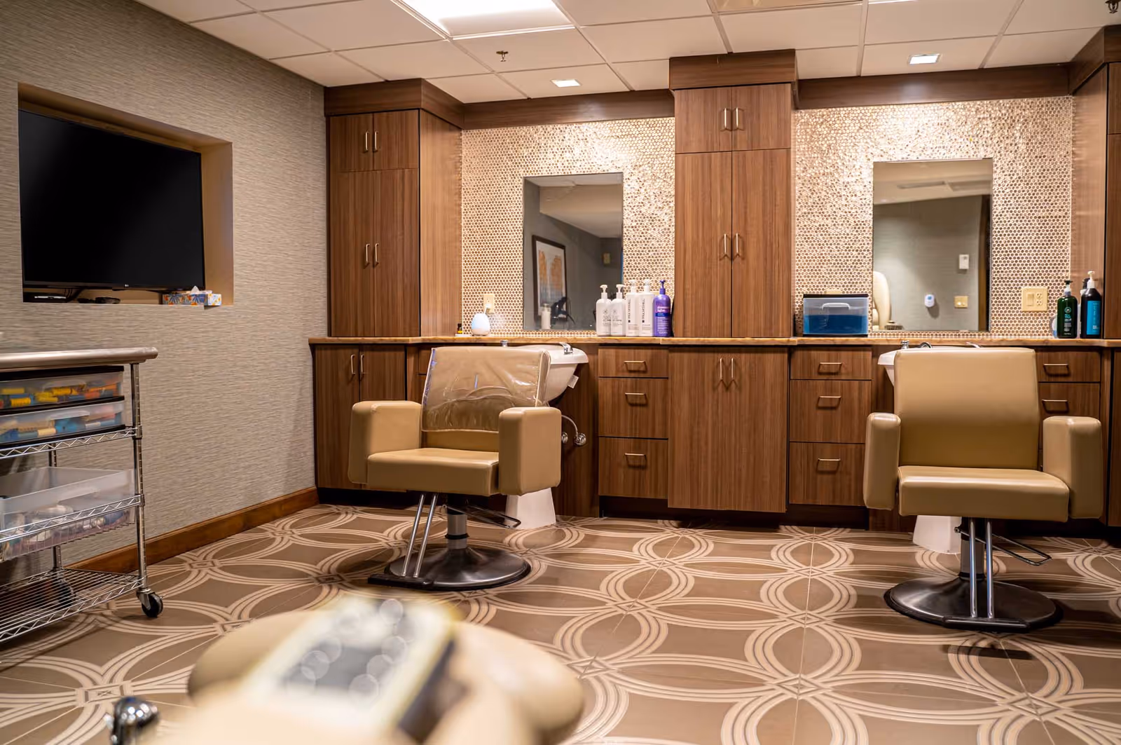 Salon/styling area with two salon chairs, mirrors, and wooden cabinetry in a well-appointed interior space.