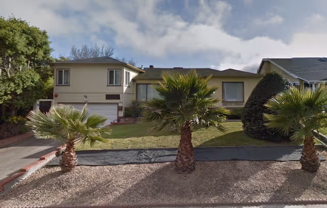 Front exterior of Golden Age Retirement Home, a single-story building with palm trees and a driveway.