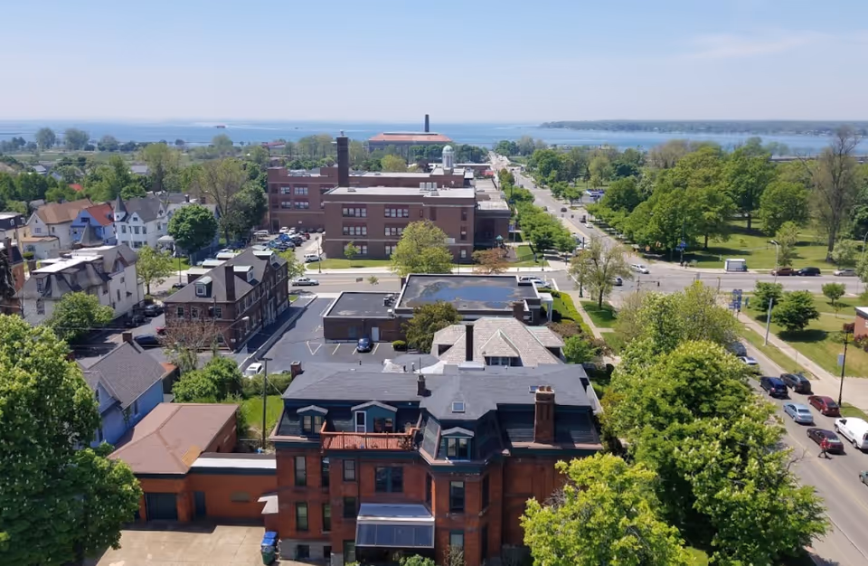 Aerial view of Mary Agnes Manor and surrounding neighborhood with tree-lined streets and a lake visible in the background.