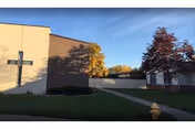 Exterior view of Davenport Lutheran Home building with a cross facade and fall trees.
