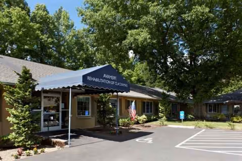 Exterior view of Avamere Rehabilitation of Clackamas entrance with a blue canopy
