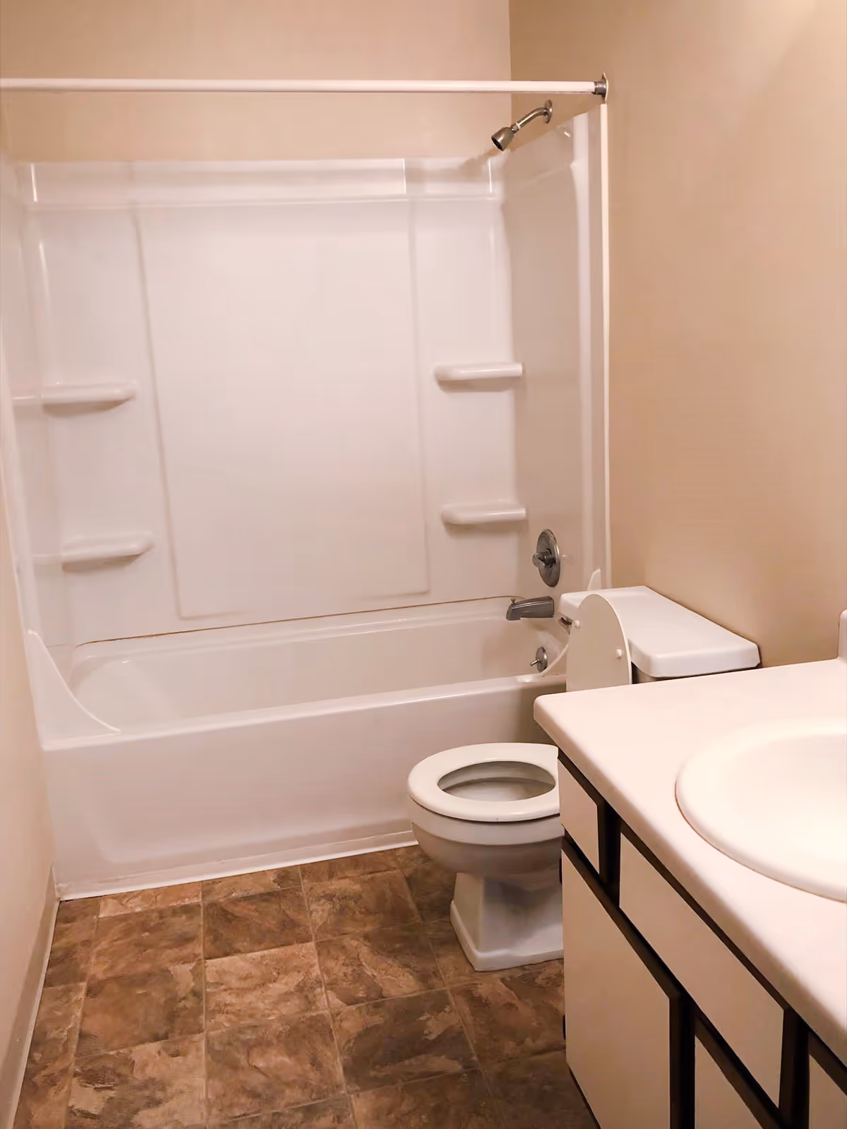 Small bathroom with a bathtub/shower, toilet, and sink vanity.