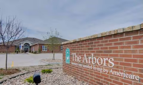 Exterior view of The Arbors at Waldron Place entrance with brick sign.