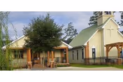 Exterior view of Resthaven Living Center Ltd: beige building, tree, and front porch.