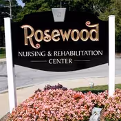 Rosewood Nursing and Rehabilitation Center sign with pink flowers and manicured landscaping.
