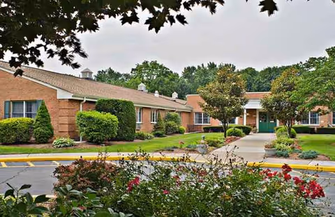 Front exterior view of Ridgewood Center brick building with landscaped entrance.