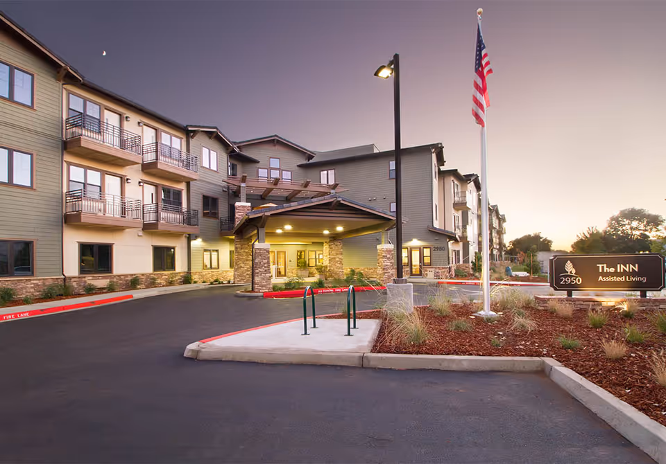 Exterior view of Westmont of Chico, The Inn, showing entrance, driveway, and sign.