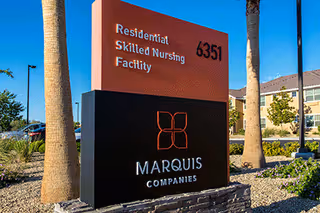 A sign for Marquis Companies marks the Residential Skilled Nursing Facility at Centennial Hills with landscaping.